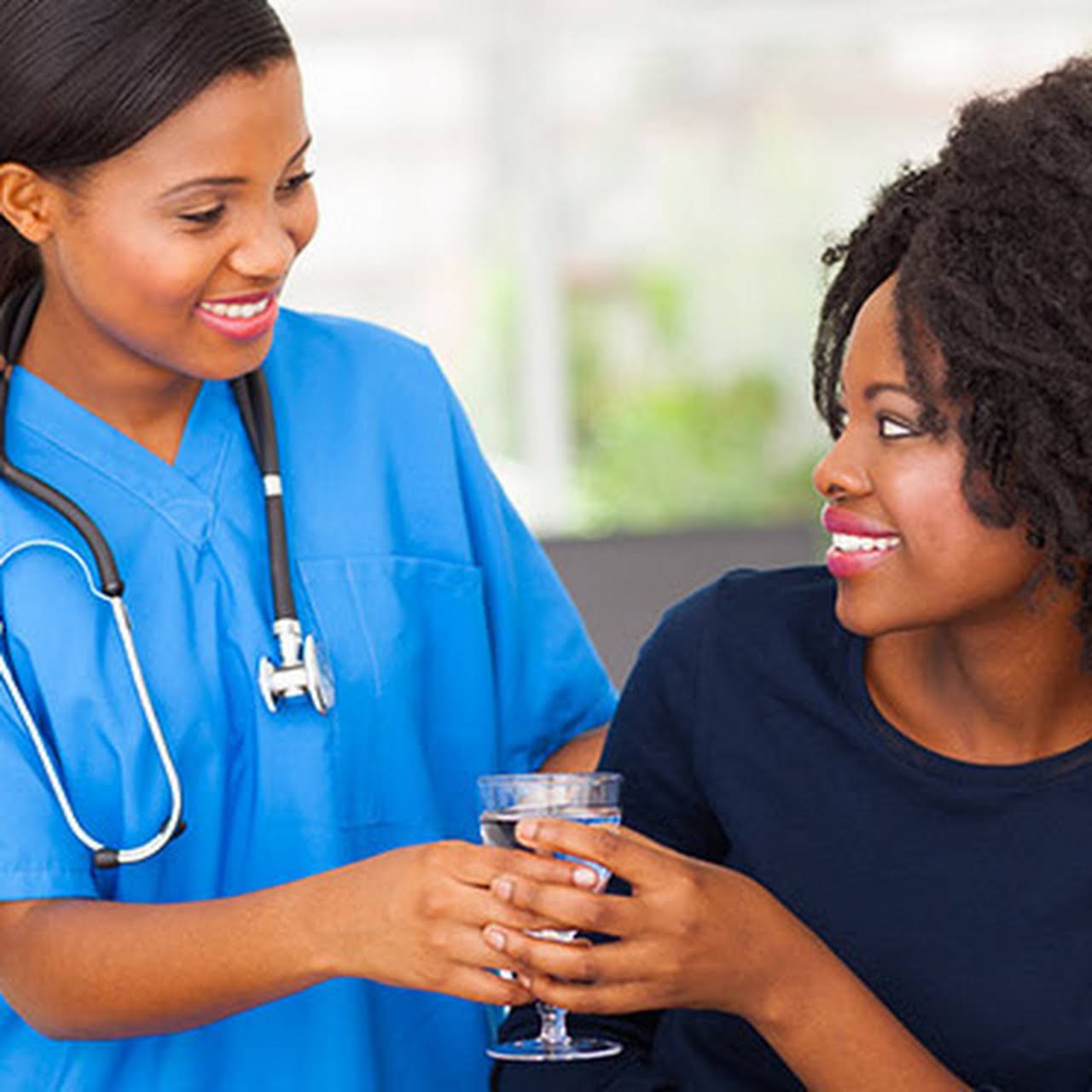 Nurse warmly supporting a woman in a healthcare setting
